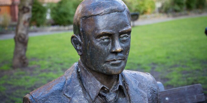 A statue of Alan Turing on a park bench in Manchester.